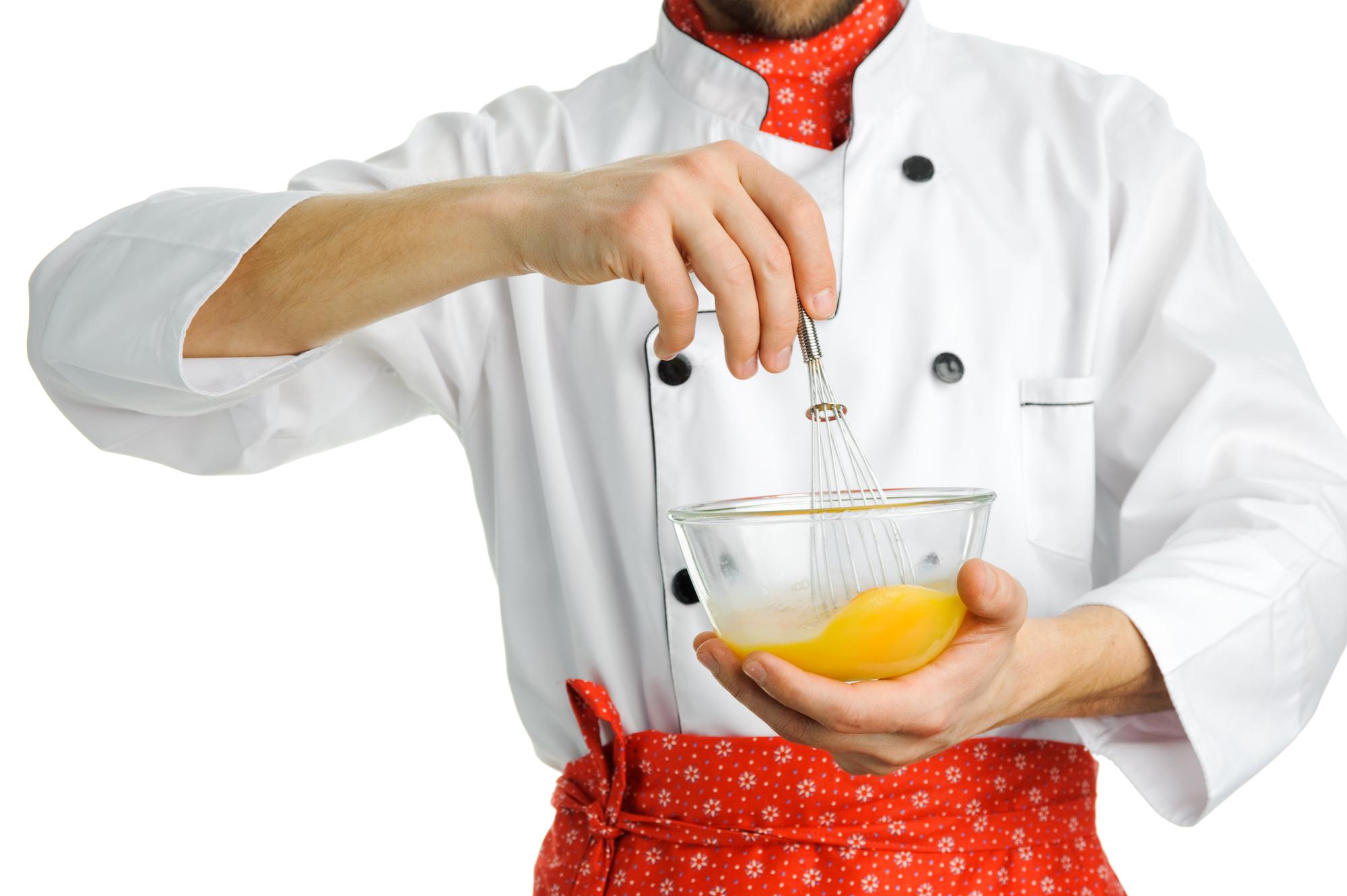 Insegnante che assaggia una preparazione in cucina professionale